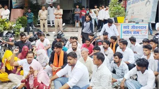 हसनपुर में अस्पताल के बाहर धरने पर बैठे बजरंग दल के कार्यकर्ता और युवती का परिवार।
