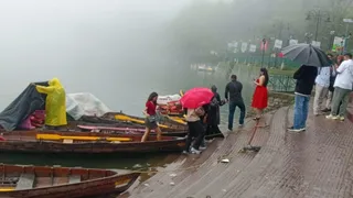 नैनीताल में बारिश के दौरान भी नौकायन के लिए खड़े पर्यटक। जागरण।