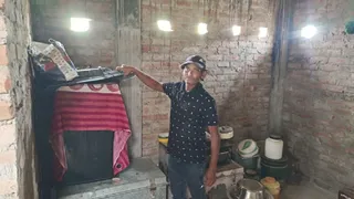 प्रयागराज में द्रोपदी घाट स्थित कछार बस्ती में घर के ऊपरी तल पर पहुंचाई गई गृहस्थी दिखाते रमेश। जागरण