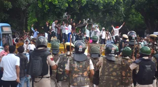 कनाॅट प्लेस स्थित संसद मार्ग पर बैरिकेड पर चढ़कर नारेबाजी करते प्रदर्शनकारी। विपिन शर्मा