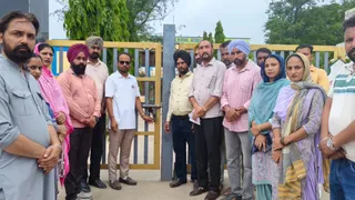 स्कूल के बाहर ताला जड़ते हुए अभिभावक।