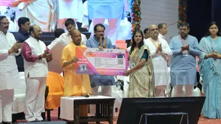 योजना का प्रतीकात्मक कार्ड देते सीएम योगी आदित्यना। फोटो क्रेडिट: अमित शिवहरे।