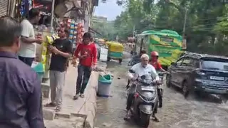 मैदानगढ़ी के अनुपम एन्क्लेव में सड़कों पर जलभराव के बीच से गुजरते वाहनचालक। जागरण