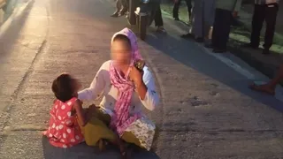बच्चे के साथ सड़क पर बैठी महिला। जागरण