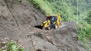 देहरादून जौनसार-बावर में भारी के कारण बंद मोटर मार्ग को खोलती जेसीबी मशीन।