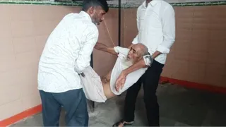 जिला अस्पताल में स्ट्रेचर न मिलने पर हाथों पर उठाकर अपने मरीज को ले जाते युवक। जागरण