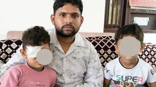 चोट लगने के बाद शुक्रवार को पिता मनोज की गोद में बैठा अनमोल (बाएं), साथ में आर्यन (दाएं) जिसके कान में चोट लगी है : जागरण