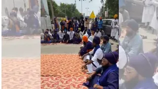 सड़क पर बैठी संगत व निहंग।