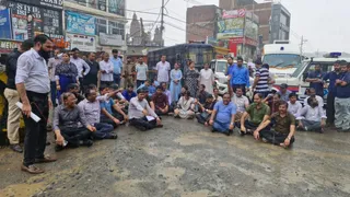 रोके जाने के बाद वर्षा में भी सड़क पर धरना पर बैठे कार्यपालक अधिकारी। जागरण