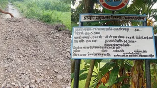 तोड़ी गई पुरानी पक्की सड़क व सड़क निर्माण से संबंधित लगा प्राक्कलन का बोर्ड। जागरण।