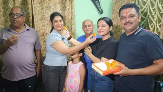 डिफेंस कॉलोनी स्थित कांस्य पदक विजेता उन्नति शर्मा के स्वजन एक दूसरे को मिठाई खिलाते हुए। साभार स्वजन