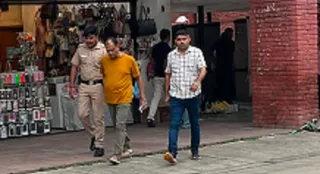 विक्रम वधवा को होटल से लेकर जाती पुलिस टीम।