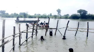 हरिबाबा बांध पर लगे बांस बल्ली के घेरे में नहाते लोग। जागरण