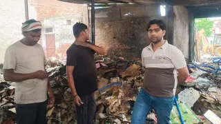 मलपुरा में गत्ते के गोदाम में लगी आग के बाद मलबा हटाने में जुटे लोग।