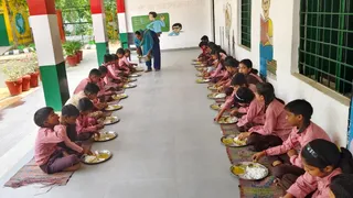 प्राथमिक विद्यालय में मध्याह्न भोजन करते विद्यार्थी। जागरण आर्काइव