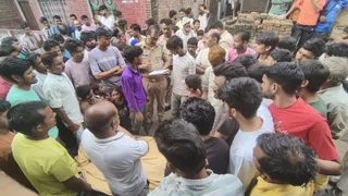 मैनपुरी में युवक के शव के पास खड़े परिवार के लोग।