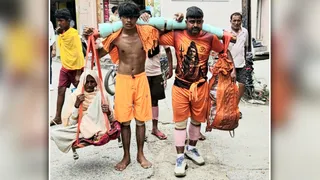 मंडी धनौरा से अपनी माता को कांवड़ में बैठाकर गुजरते हापुड़ के कांवड़िये।जागरण
