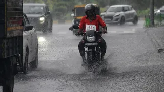 नई दिल्ली में भारी बारिश के बीच एक राइडर बारिश से गीली सड़क पर गाड़ी चलाता हुआ। फोटो- एएनआई