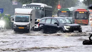 द्वारका सेक्टर-2 में सड़क पर वर्षा से हुए जलभराव के बीच गुजरते वाहन। जागरण