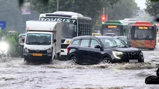 द्वारका सेक्टर-2 में सड़क पर वर्षा से हुए जलभराव के बीच गुजरते वाहन । हरीश कुमार