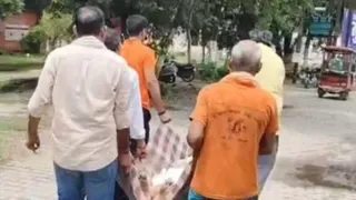 वायरल वीडियो में बुजुर्ग को गद्दे में लेकर जाते लोग। जागरण