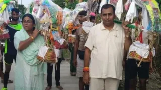 सिरसागंज के सपा विधायक सर्वेश यादव (दाएं) अपनी पत्नी रामबेटी यादव (बाएं) के साथ कांवड़ ले जाते हुए
