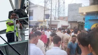 टावर पर चढ़ी महिला और नीचे जमा लोगों की भीड़
