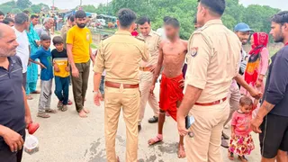नहर से बाहर निकालने के बाद युवक से पूछताछ करती पुलिस।