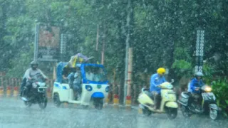 मुरादाबाद में भारी बारिश के बीच गुजरते लोग। जागरण