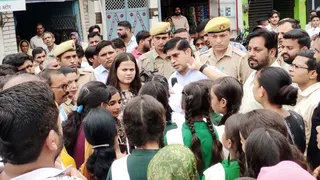 देशी शराब की दुकान को हटाने के विरोध में धरना-प्रदर्शन कर रहे स्कूली बच्चों को कार्रवाई का आश्वासन देते जिलाधिकारी डॉ. राजेंद्र पेंसिया। जागरण