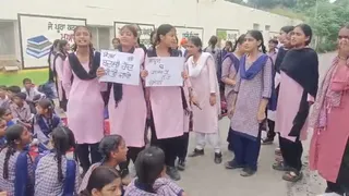 हाथ में पोस्टर पकड़ मांग रखते हुए स्टूडेंट्स।