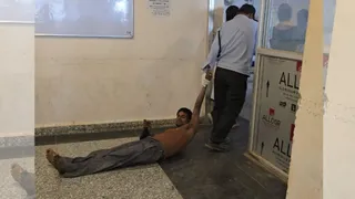 दरभंगा के डीएमसीएच में मरीज को घसीटकर ले जाते गार्ड। जागरण