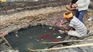 प्रयागराज में जलभराव से मुक्ति को नगर निगम का अनोखा प्रयोग: सोहबतियाबाग स्थित संगम पेट्रोल पंप के पास बने नाले में लाल रंग डालकर पानी का बहाव परखते श्रमिक। जागरण
