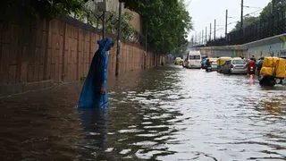 पंचकुइयां रोड पर वर्षा के पानी से होकर गुजरते वाहन चालक व लोग। जागरण