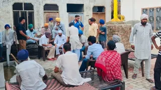 ग्राम पंचायत की कार्यवाही के दौरान मौजूद लोग।