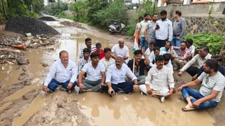 दलदली सड़क पर समर्थकों संग बैठकर प्रदर्शन करते इंदौर शहर कांग्रेस अध्यक्ष चिंटू चौकसे।