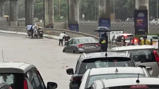 गोल्फ कोर्स रोड पर जलभराव में बंद पड़ी सियाज कार। जागरण