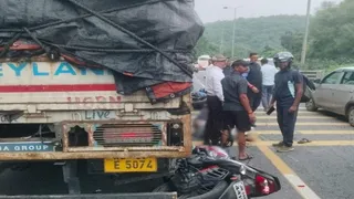 दुर्घटनाग्रस्त ट्रेलर के चक्के में घुसा बाइक।