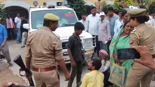 एसडीएम के गाड़ी के आगे बैठ कर प्रदर्शन करते पीड़ित परिवार के सदस्य।