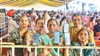 महिलाओं के खाते में आए पैसे, मोबाइल में दिखातीं महिलाएं। फोटो जागरण