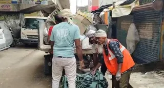 नौशाद के गोदाम से जब्त पटाखा व बारूद को ले जाते कर्मी।
