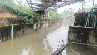 रेलवे ट्रैक पर भरे पानी को मोटर से निकालते कर्मचारी
