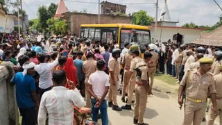 स्कूली बस को घेरकर खड़े ग्रामीणों को हटाती पुलिस।