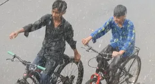 गोरखपुर में बारिश का आनंद उठाते साइकिल सवार। जागरण