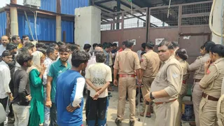 मथुरा में साड़ी फैक्ट्री के बाहर हंगामा करती भीड़ और पुलिस फोर्स।