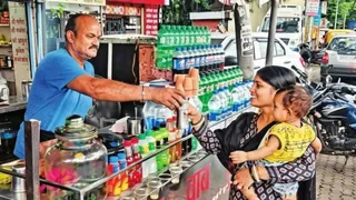 झारखंड से राजगीर पहुंचीं महिला पर्यटक के बच्चो को दूध की बोतल देते रंजीत उर्फ टुन्ना बाबा। फाइल फोटो