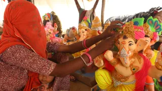 जम्मू में भगवान गणेश की मूर्ति को संवारती महिला। (फोटो- जागरण)
