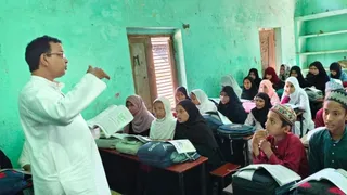 मदरसा दारूल उलूम कुद्दूसिया अहले सुन्नत फखरुल उलूम परसौनी बाज़ार में बच्चों को हिंदी पढ़ाते शिक्षक जहांगीर अली अंसारी
