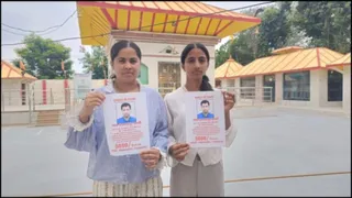 लापता पिता का पोस्टर लिए खड़ी दोनों बेटियां।