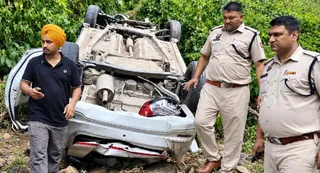 मांदना गांव के पास मोड़ पर संतुलन बिगड़ने पर कार गहरी खाई में गिरी। जांच करते पुलिस कर्मी।